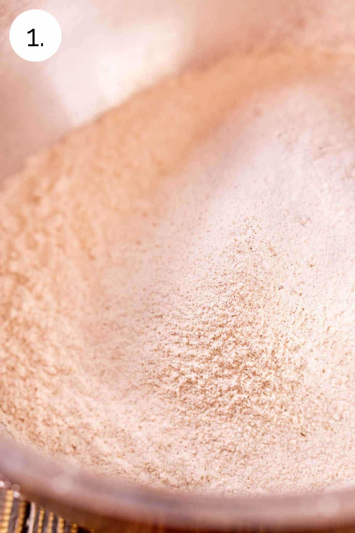 The flour mixture in a large stainless steel mixing bowl after sifting together.