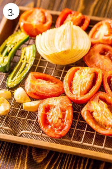 The vegetables on a gold sheet pan with a wire rack after they've been removed from the smoker.