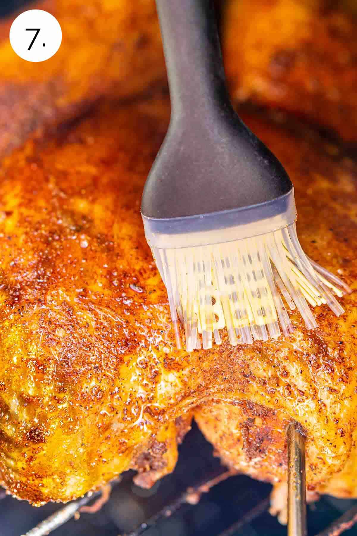 A silicone brush coating the chicken with a layer of olive oil before cranking up the heat of the smoker.