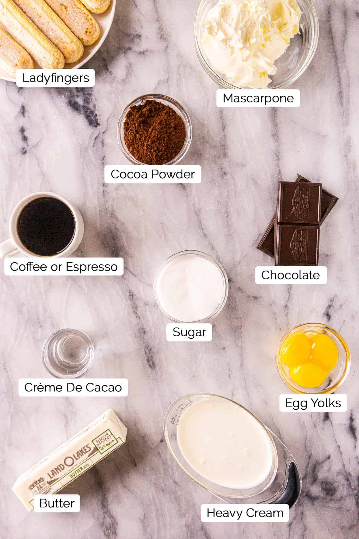 The ingredients on a white marble countertop with black and white labels underneath the items.