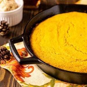 A close-up of the sweet potato cornbread on a colorful napkin with fall decor to the left.