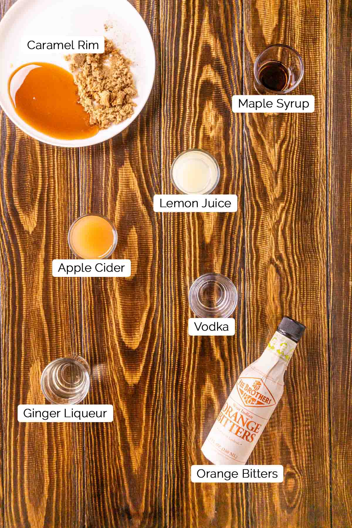 The drink ingredients on a brown wooden surface with black and white labels by the items.