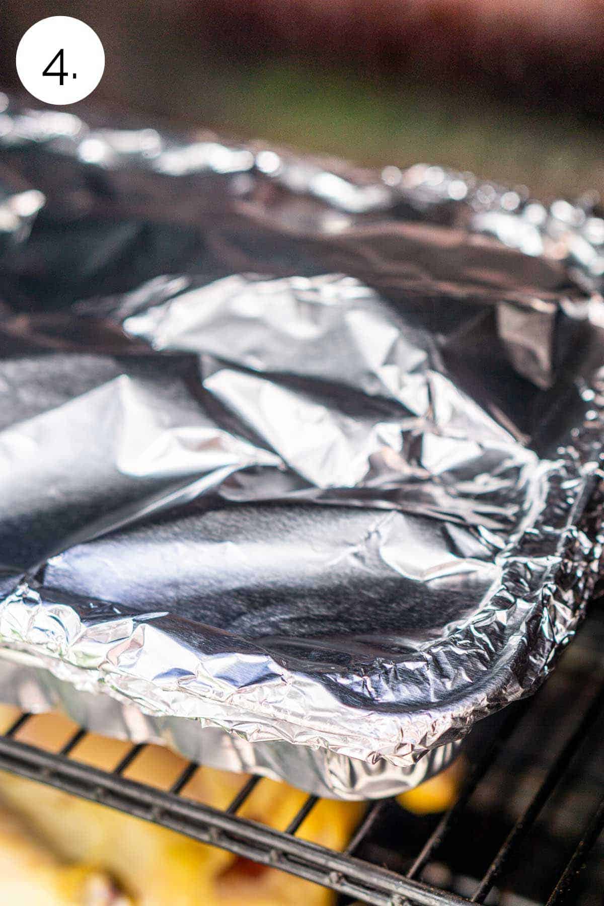 The aluminum foil-covered pan back in the smoker to finish the second half of the cooking process.