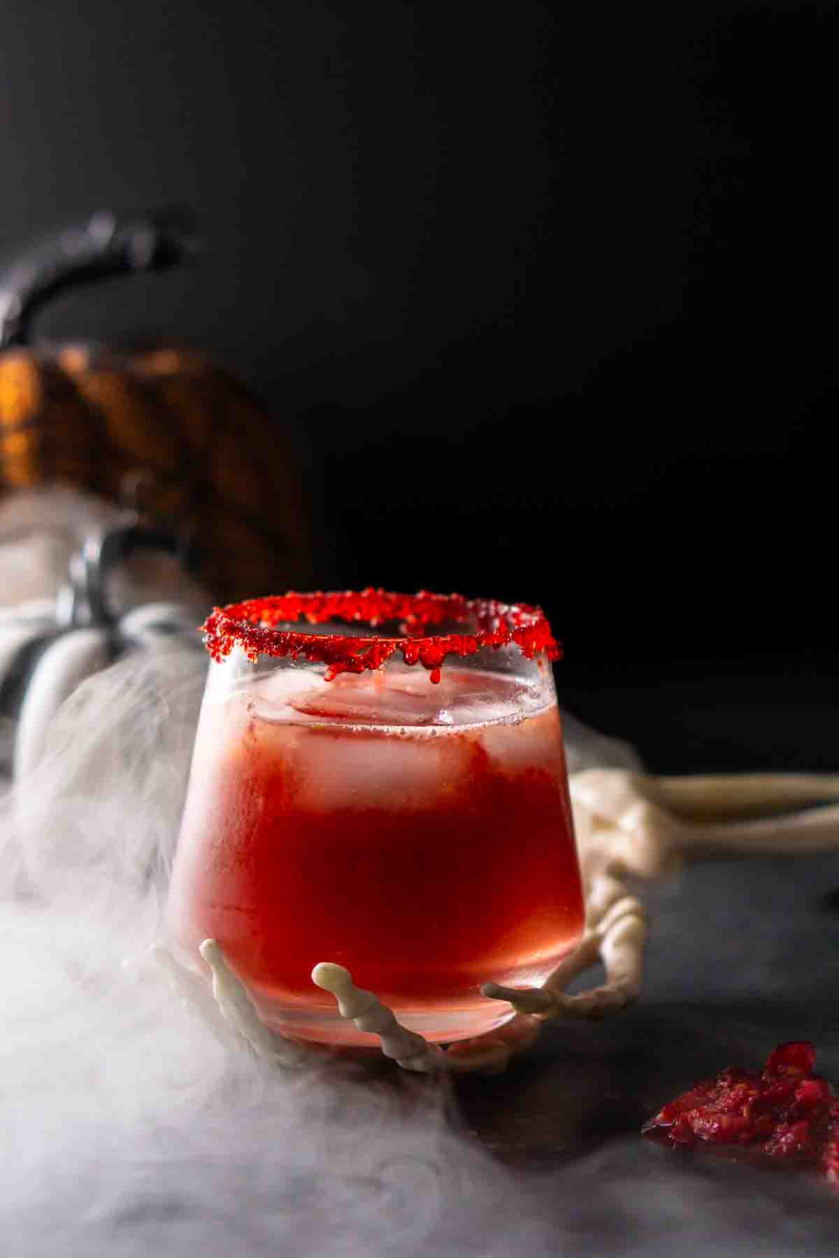 A Zombie Brains Halloween Cocktail against a black surface with a cloud of mist coming in from the left.