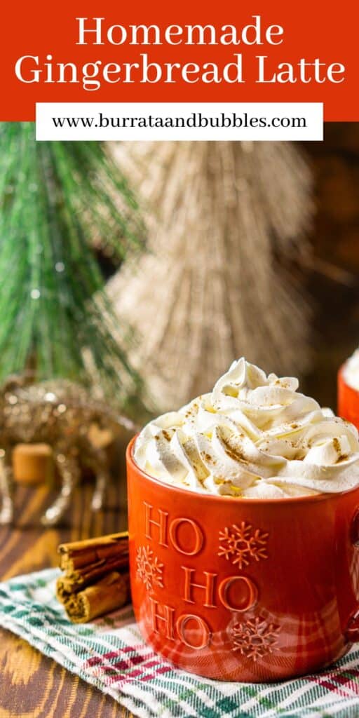 A red coffee mug filled with a gingerbread latte topped with whipped cream and holiday decor around it and text overlay on top of the image.