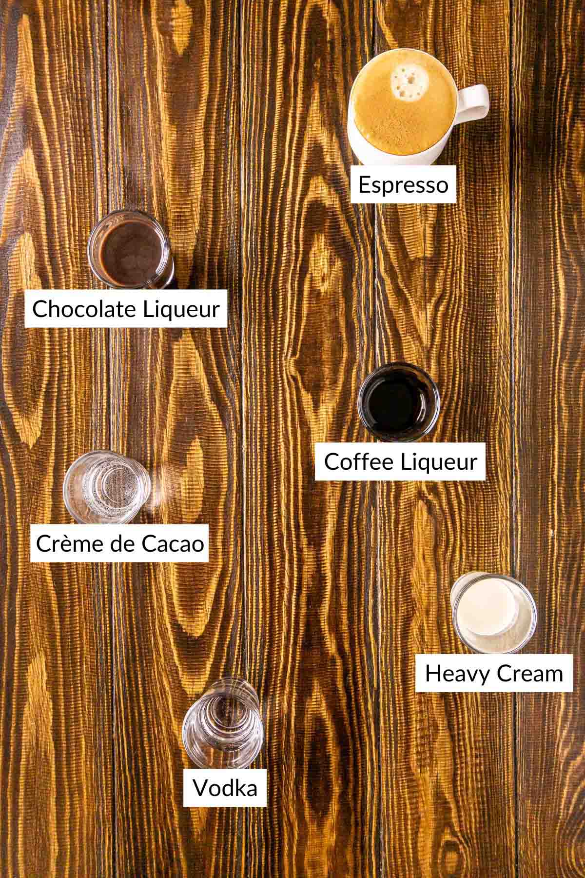 The cocktail ingredients on a wooden board with white and black labels by the items.