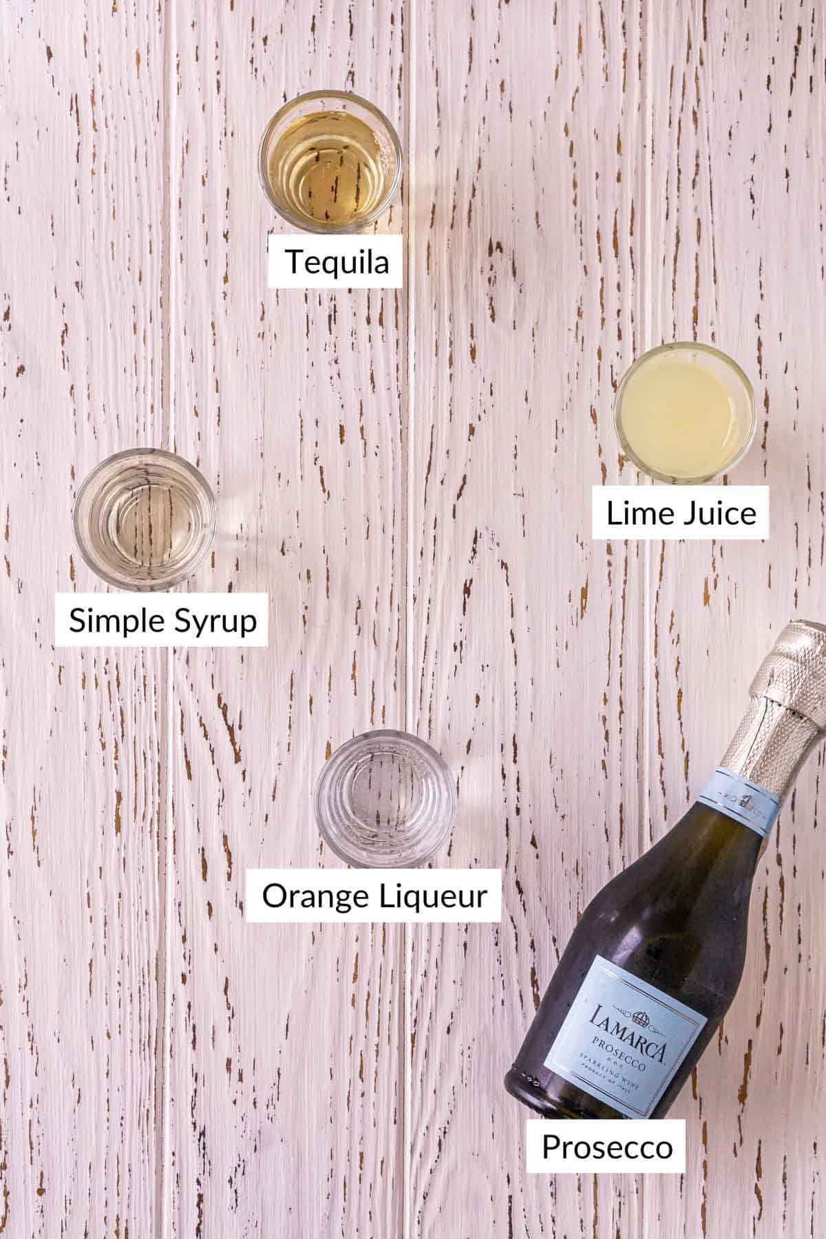 The drink ingredients on a white wooden surface with white and black labels by the items.