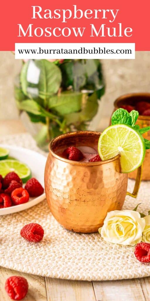 A raspberry Moscow mule with a white plate full of lime slices and raspberries to the left and flowers in the background with text overlay on top.