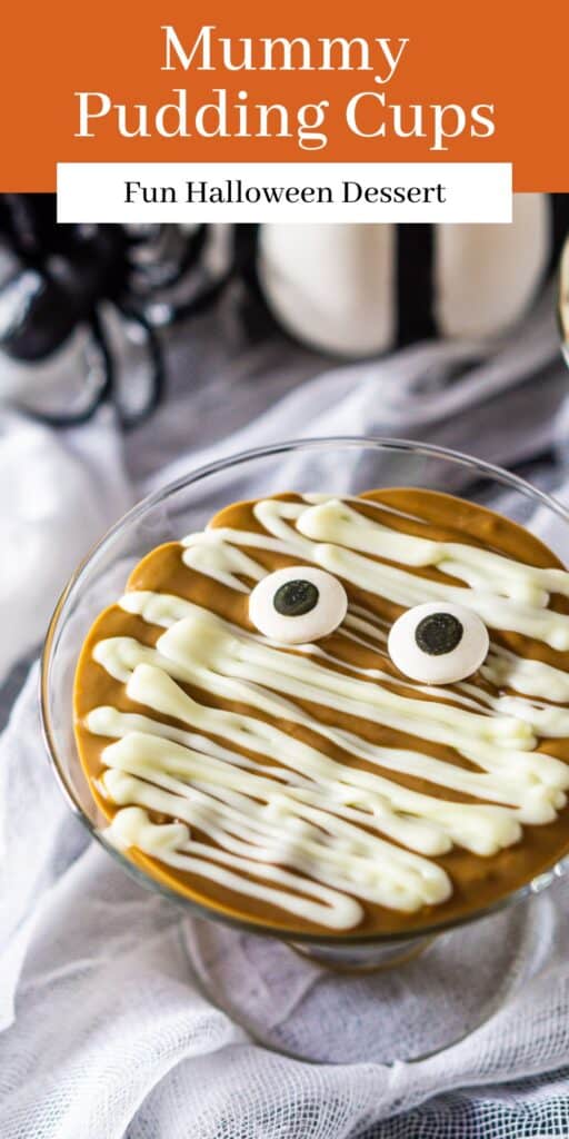 A mummy pudding cup on white fabric with Halloween decor around it and text overlay on top of the image.